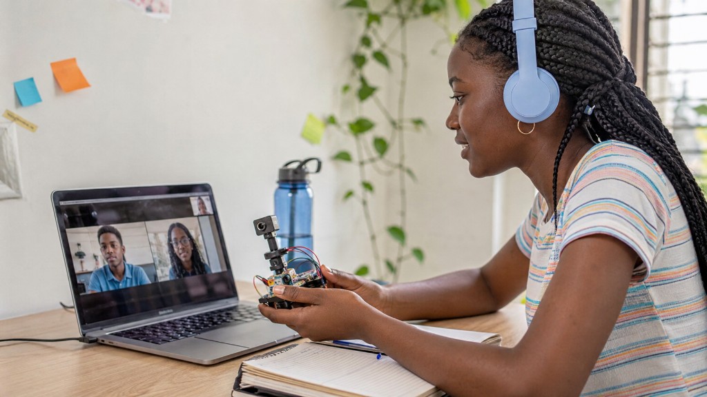 A learner holding up a robot kit on a video call with her Coasted Code class