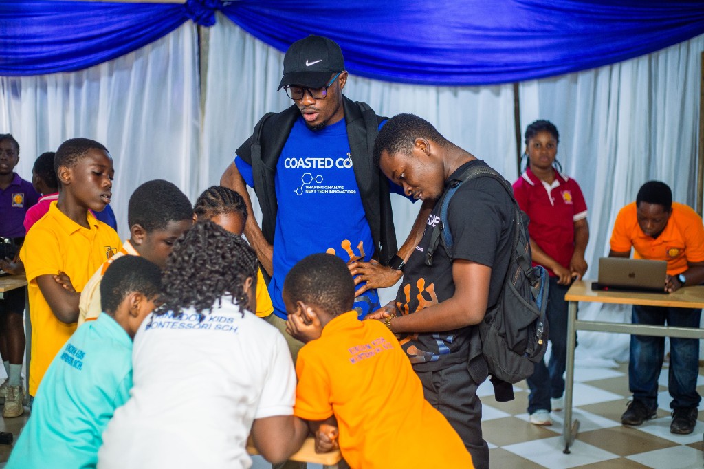 Young students at Kingdom Kids Montessori gathered around a table with Coasted Code instructors